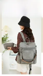 Grey pebbled leather backpack for women with matching wristlet and woven strap detail