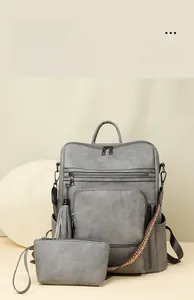 Detail of grey pebble leather backpack with ethnic woven straps and detachable front pouch