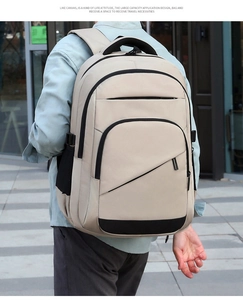 Macro detail of the beige outdoor backpack showing mesh side pocket and zipper compartments