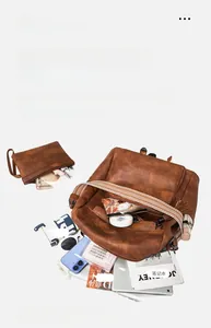 Detailed interior storage of brown leather backpack with 14 inch laptop and accessories