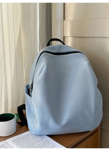 Hellblauer Netzrucksack mit Seitentasche auf einem Tisch, ideal für Reisen und Pendeln
