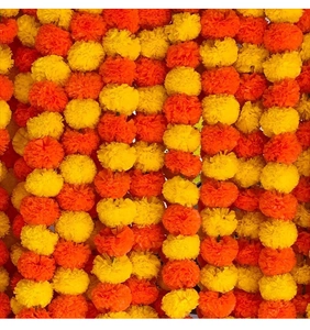 Close-up of vibrant orange and yellow artificial marigold garlands for festive decoration