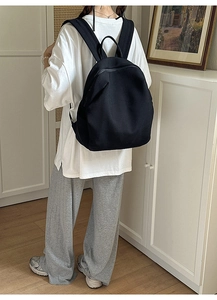 Minimalistischer schwarzer atmungsaktiver Rucksack in einem Lifestyle-Innenraum