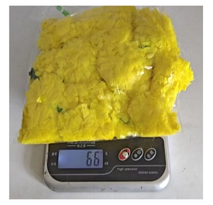Detailed shot of yellow artificial marigold petals on a scale weighing 66g for decor