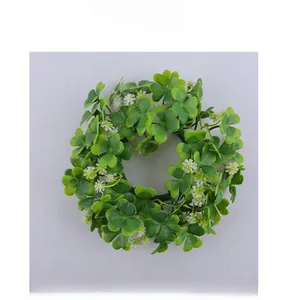 Dettaglio ghirlanda di candele con trifoglio artificiale e fiori bianchi per la tavola