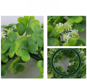Dettaglio macro della mini ghirlanda per candele di San Patrizio con trifogli e margherite