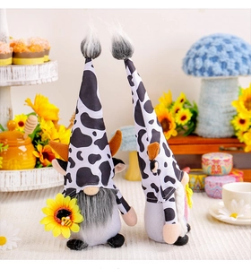 Détail de deux gnomes en peluche motif vache avec tournesol et abeille pour la maison