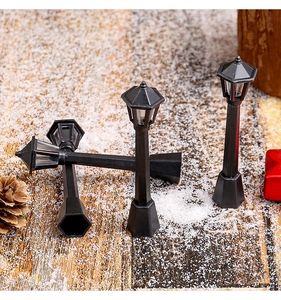 Modelo de farola negra vintage en miniatura con nieve artificial sobre madera rústica