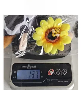 Poupée en peluche tournesol et abeille pesée sur une balance affichant 137 grammes