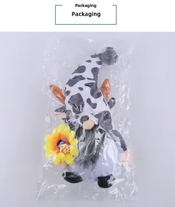Gnome en peluche avec chapeau à motif vache tenant une tournesol sous emballage plastique