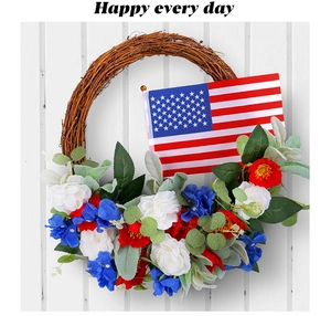 Detail of Fourth of July wreath with red white blue flowers and US flag on white wood