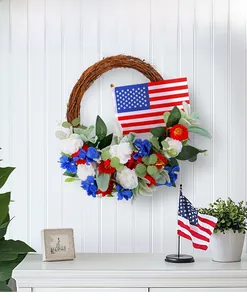 Detail of Fourth of July grapevine wreath with patriotic flowers and small American flag