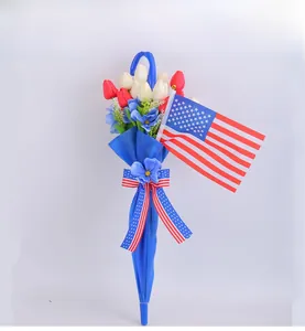 Detail of red and white tulip floral arrangement in a blue umbrella with US flag accent