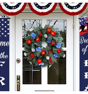 Close-up of patriotic wreath with red, blue, and white flowers on a white door