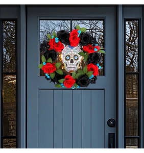 Ghirlanda di Halloween con rose rosse e nere e teschio su porta in legno grigio
