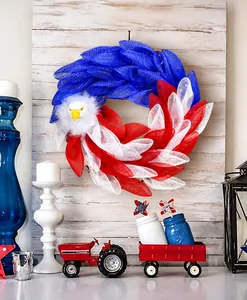 Detail of Fourth of July mesh wreath featuring a bald eagle head on a rustic wood wall