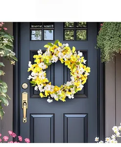 Spring wreath decoration with yellow and white flowers on a dark blue door scene