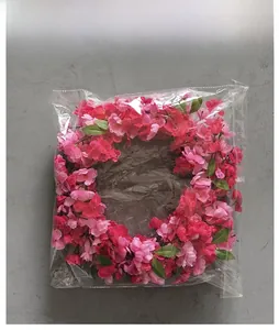 Detailed view of pink and purple floral wreath in transparent protective packaging