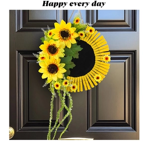 Détail d'une couronne de tournesols avec pinces en bois et feuilles tombantes sur porte noire
