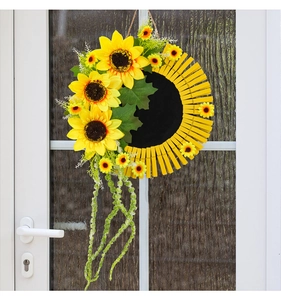 Détail d'une couronne de tournesols avec pinces en bois et centre noir sur porte