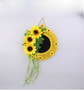 Détail de décoration murale tournesol avec pinces en bois, feuilles et corde en jute