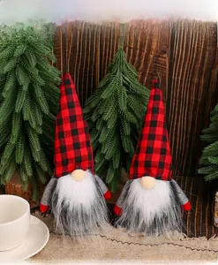 Close-up of two Christmas gnomes with red and black plaid hats on a wooden table