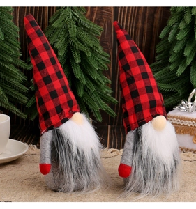 Detail of red and black plaid Christmas gnomes with faux fur beards on rustic wood background