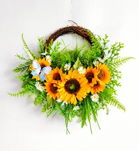 Detailansicht des Sonnenblumenkranzes mit grünen Blättern und blauem Falter auf Rebe
