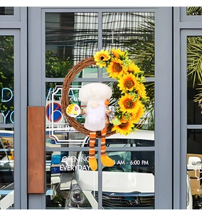 Détail de couronne de tournesols fête des abeilles avec gnome cuisinier sur porte