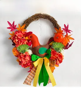 Detail view of harvest wreath with fabric rooster, maple leaves, and mini pumpkins