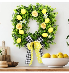 Close-up of summer lemon wreath with green leaves and a checkered bow on a white wall