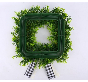 Detailed back view showing the green square plastic frame and decorative ribbons of the wreath