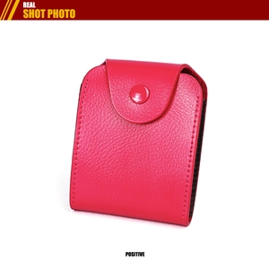 Macro view of hot pink pebble leather card holder with secure snap closure and stitching