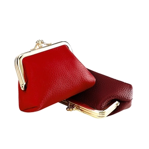 Close-up of dual-color red lychee leather kiss-lock coin purses with gold hardware