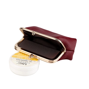 Detail view of burgundy pebble leather coin purse with golden frame and open brown lining