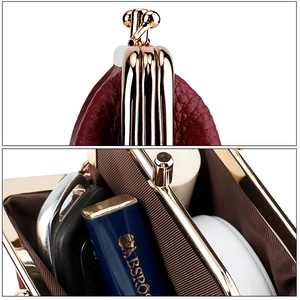 Detailed macro view of burgundy leather kiss-lock wallet with dual interior compartments