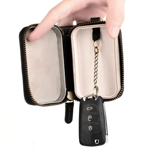 Detail view of leather key case with black lychee texture and anti-theft chain