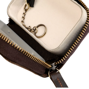 Macro shot of brown Crazy Horse leather key case interior with metal chain and ring