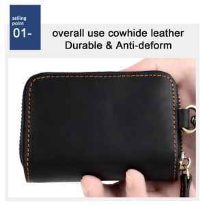 Detail of durable black cowhide leather key case with orange stitching and gold metal zipper