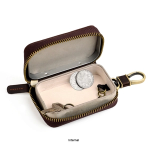 Detail showing the internal storage space of the brown leather hard case with gold zipper
