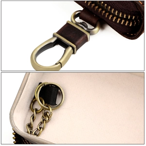 Close-up of brown leather car key case featuring vintage bronze hook and interior chain