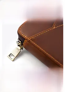 Detail of vintage brown leather pen case showing the bronze zipper and stitching