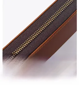 Close-up of durable golden metal zipper and brown crazy horse leather with neat stitching