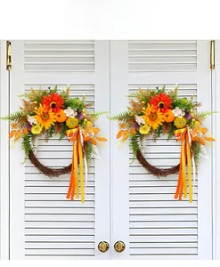 Detail view of artificial sunflower wreath with pumpkins and decorative orange ribbons