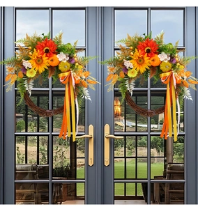 Close-up of autumn wreath with sunflowers, pumpkins and ribbons on a glass door