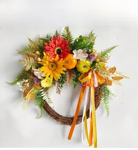 Close-up of autumn wreath featuring sunflowers, mini pumpkins and long silk ribbons