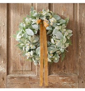 Detail of faux eucalyptus leaves and white daisies wreath with yellow velvet ribbon
