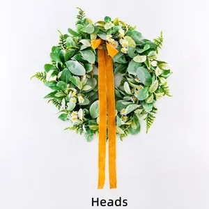 Close-up of spring wreath with green flocked leaves, white daisies, and a ginger ribbon