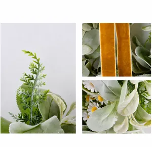 Detail of flocked grey lamb's ear leaves, white daisies and orange velvet ribbon on a wreath