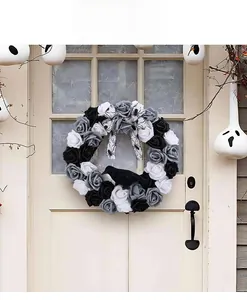 Detail of Halloween wreath with black roses, crow, and spider ribbon on door